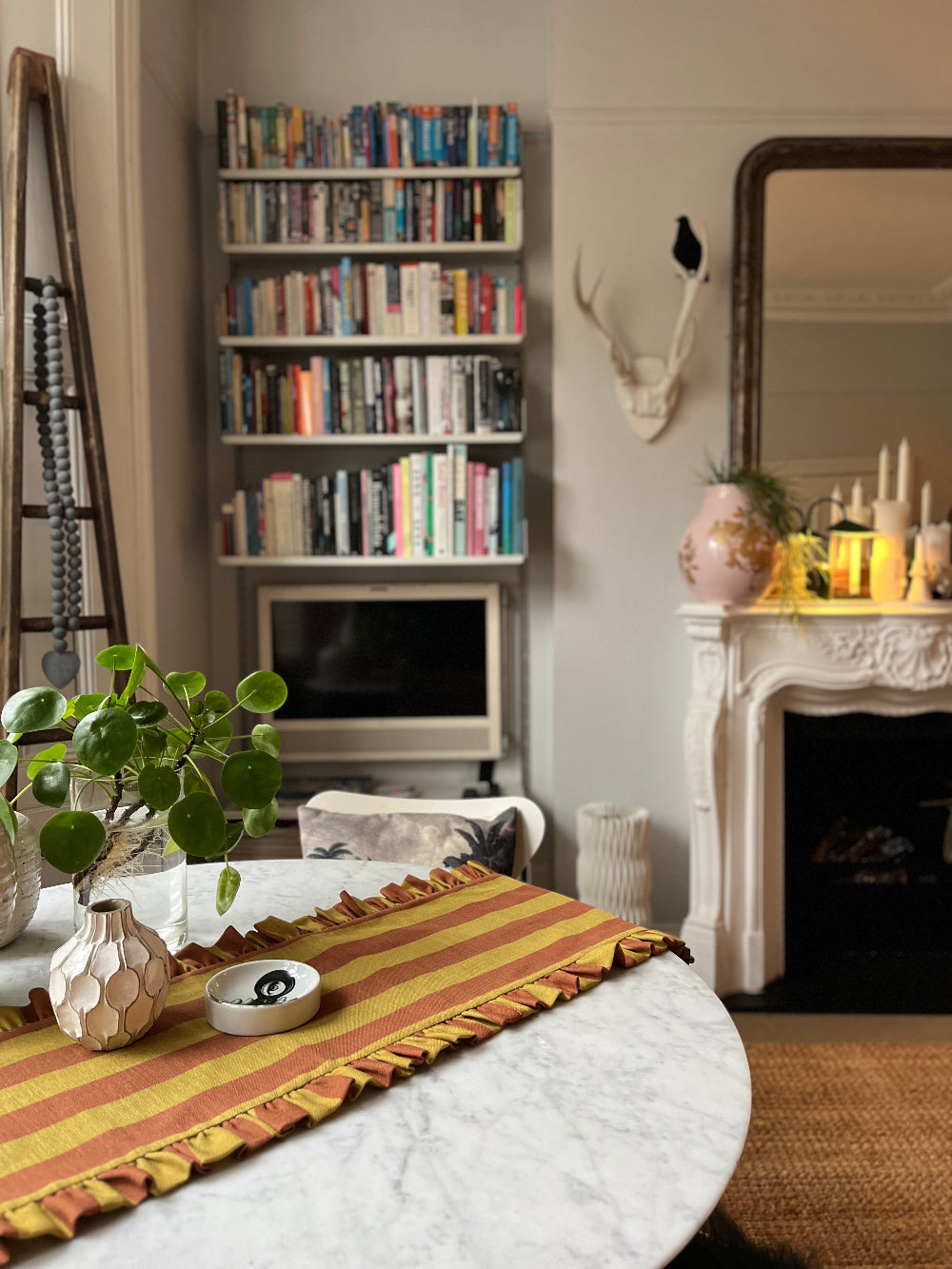 Kika Bespoke rust and mustard striped ruffled table runner styled on a round dining table