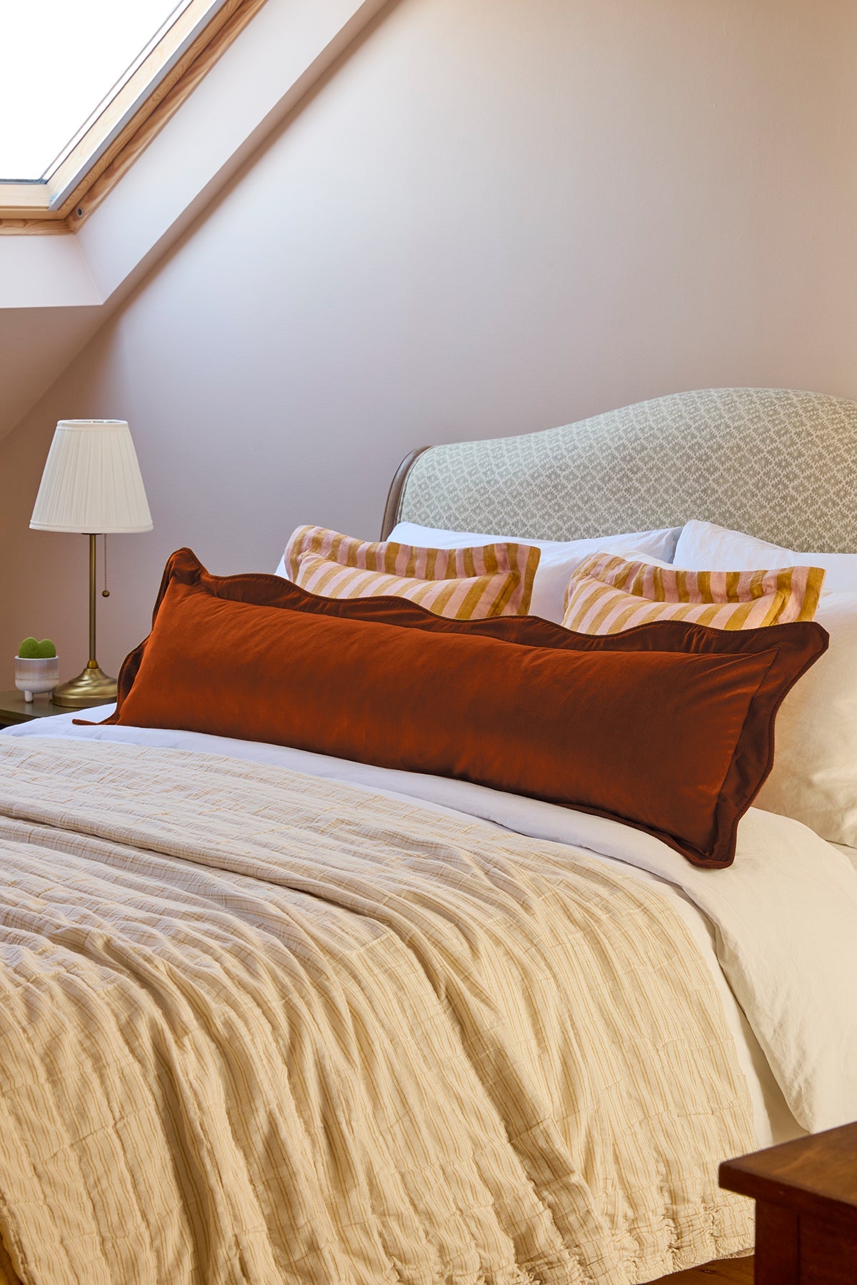 Bedroom with a bed featuring patterned headboard and pillows.