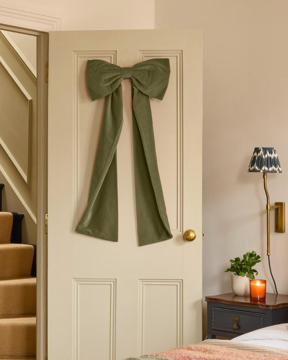 Kika Bespoke oversized sage green velvet Christmas bow displayed on an indoor door