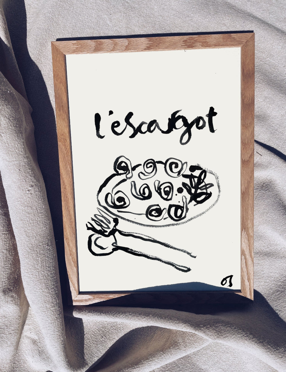 Framed artwork with 'L'escargot' and a snail illustration on a neutral background