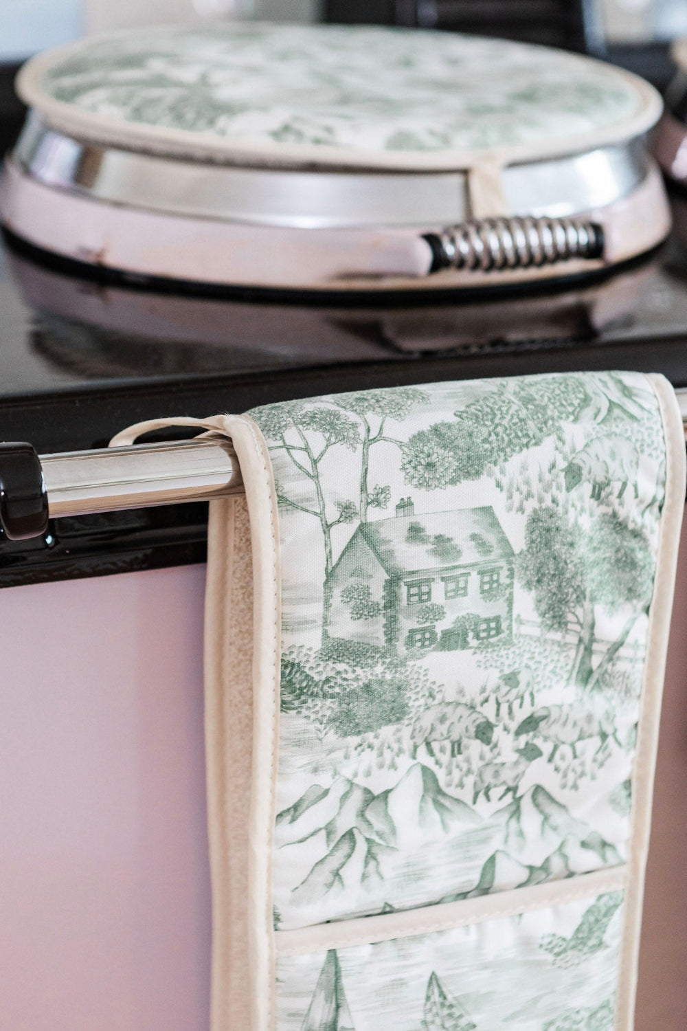Lake District Illustration Oven Mitt hanging on a pink Aga.
