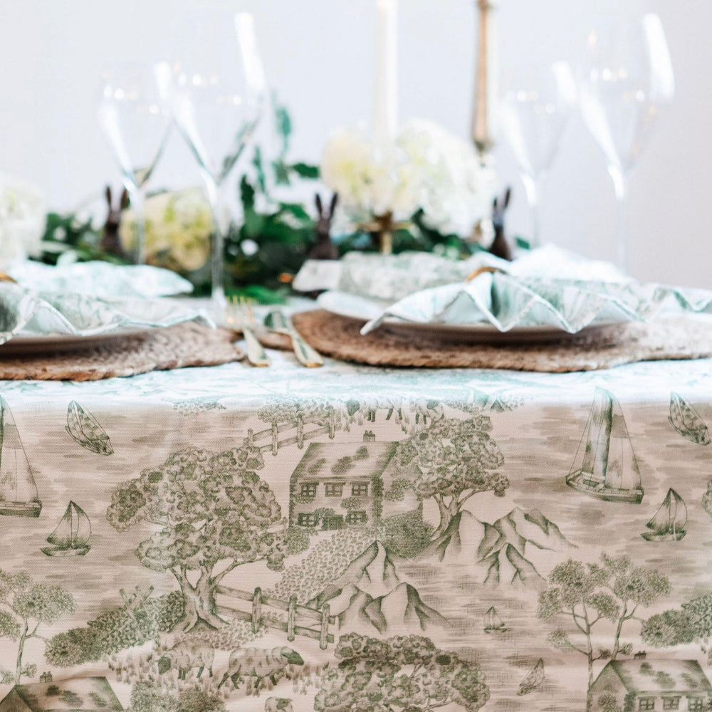 Decorative table setting with a patterned tablecloth featuring nature-themed design.