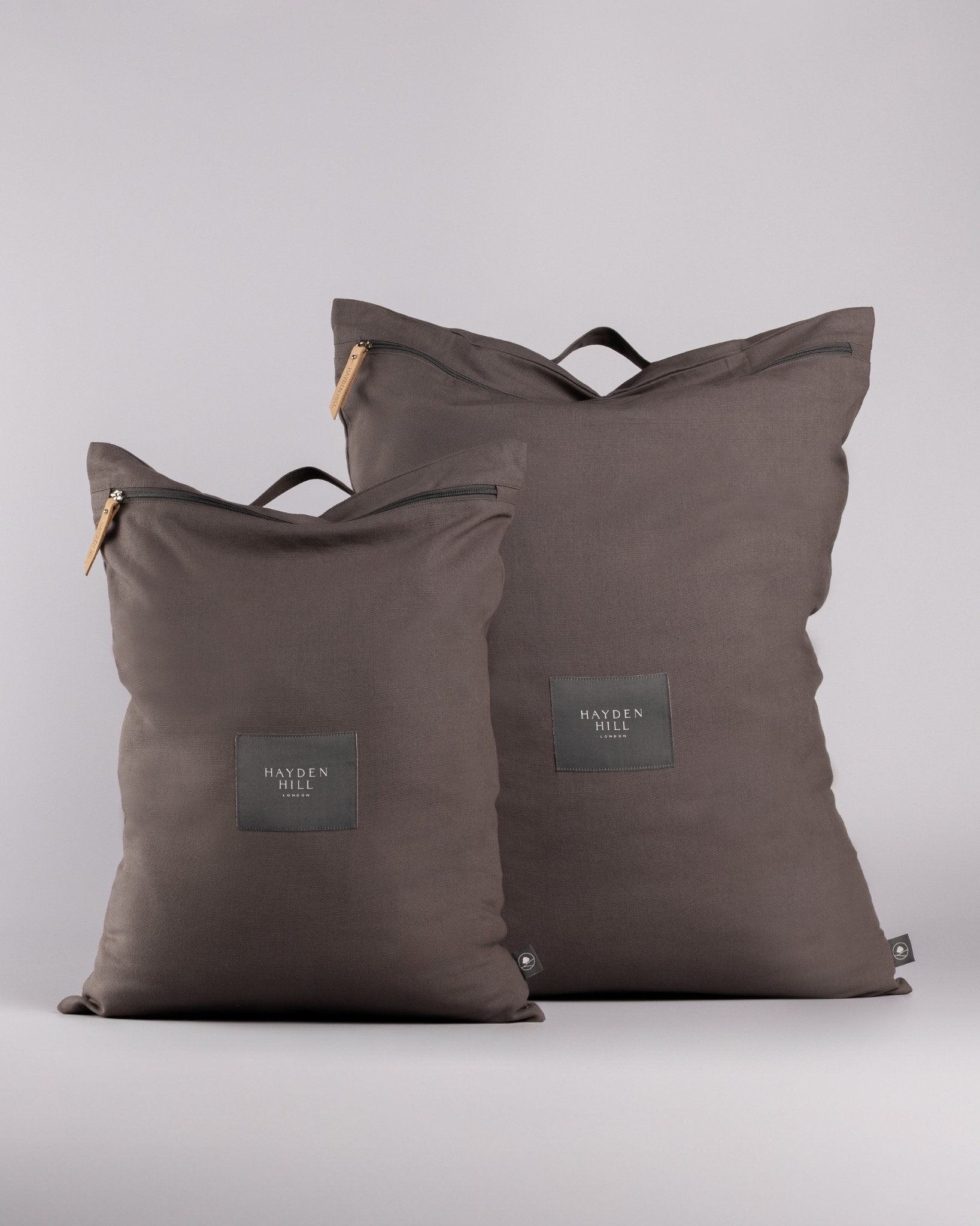 Two dark brown zippered storage bags from Hayden Hill, one small and one large, standing upright on a light grey studio background.