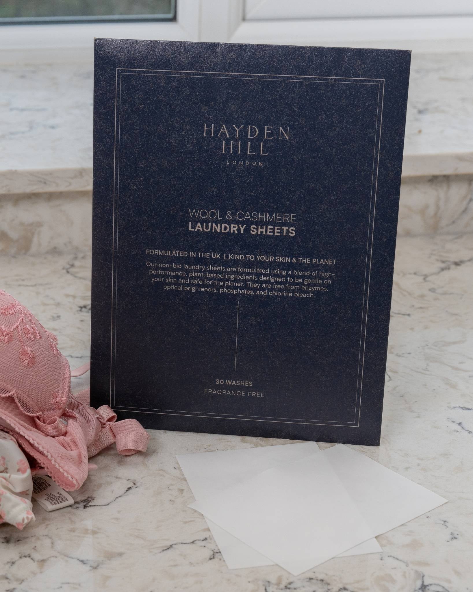 Hayden Hill laundry sheets packaging on a marble surface with a pink garment.