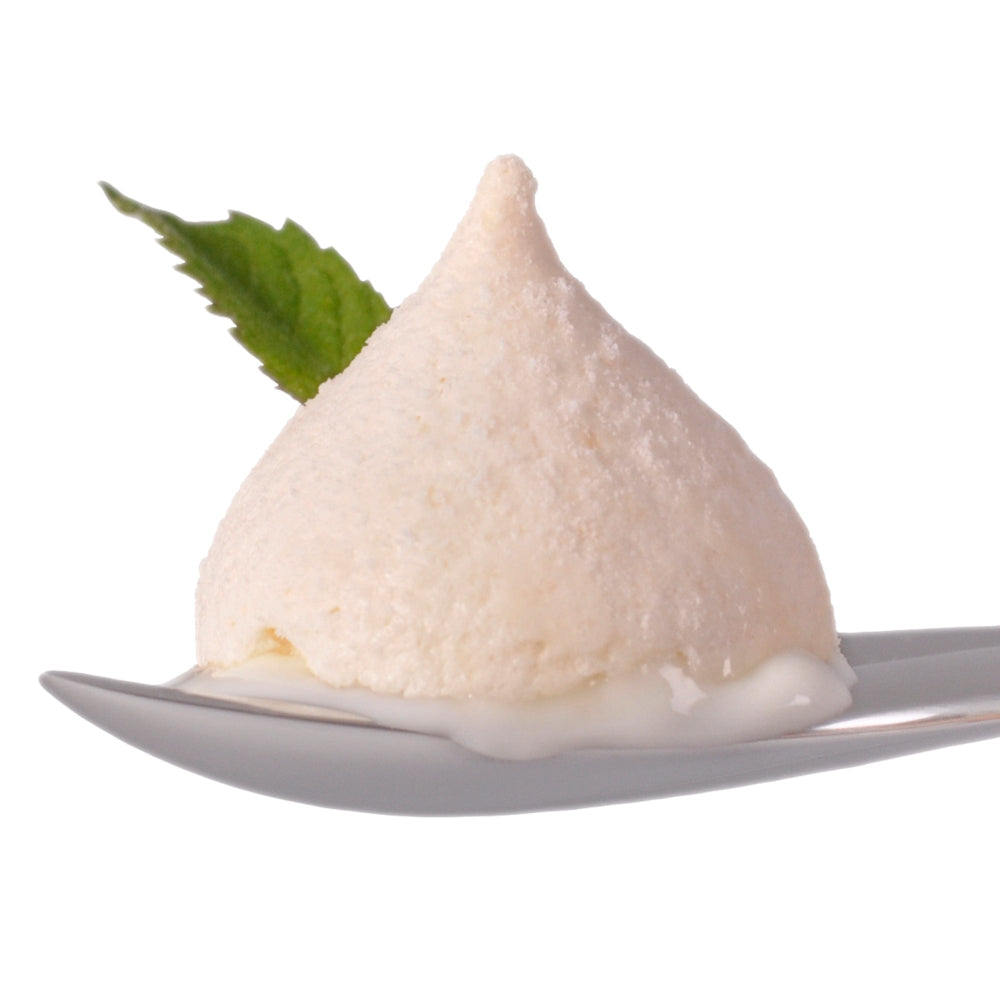 Ice cream on a leaf designed spoon with a basil leaf against a white background