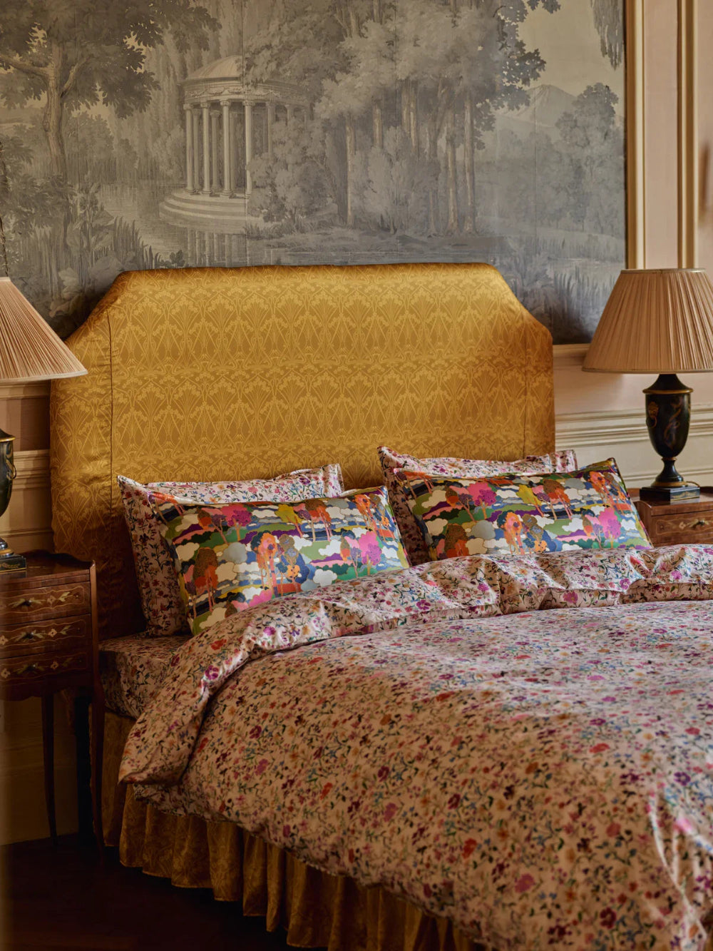 Bedroom with a gold upholstered headboard and Liberty floral Garden bedding.