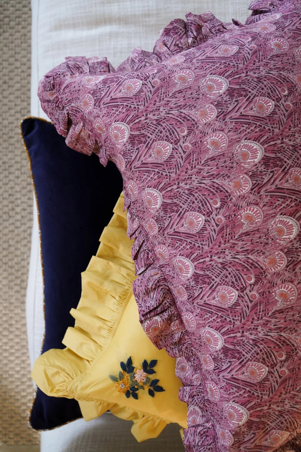 Close-up of a patterned fabric with floral embroidery on a yellow garment.