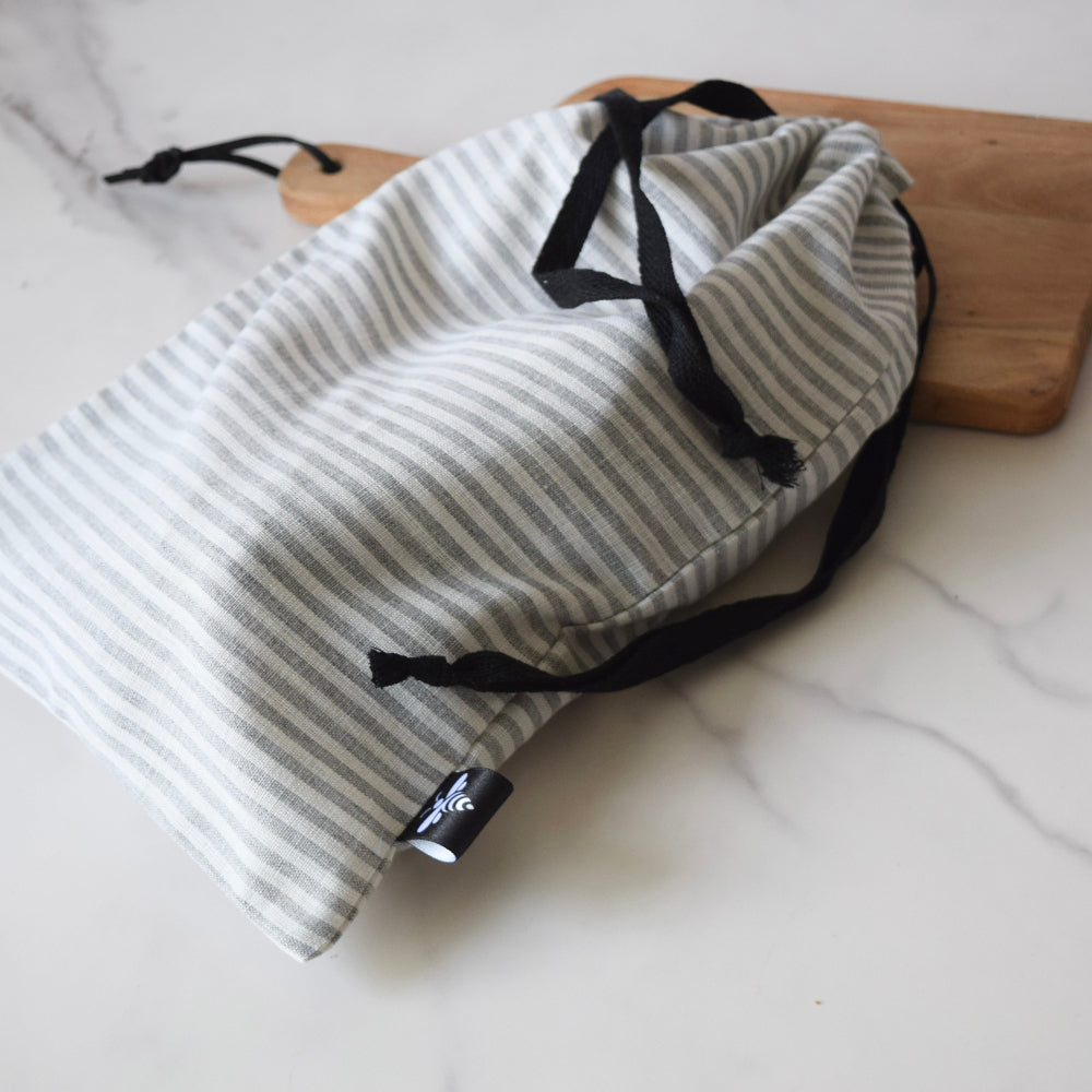 Striped drawstring bag with black drawstrings on a white surface