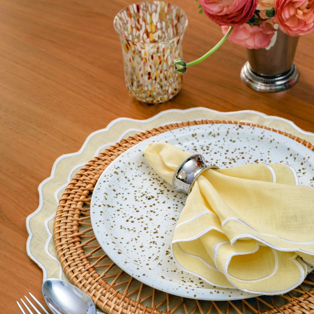 Dining table setting with a plate, buttermilk coloured napkin, and decorative elements on a wooden surface.