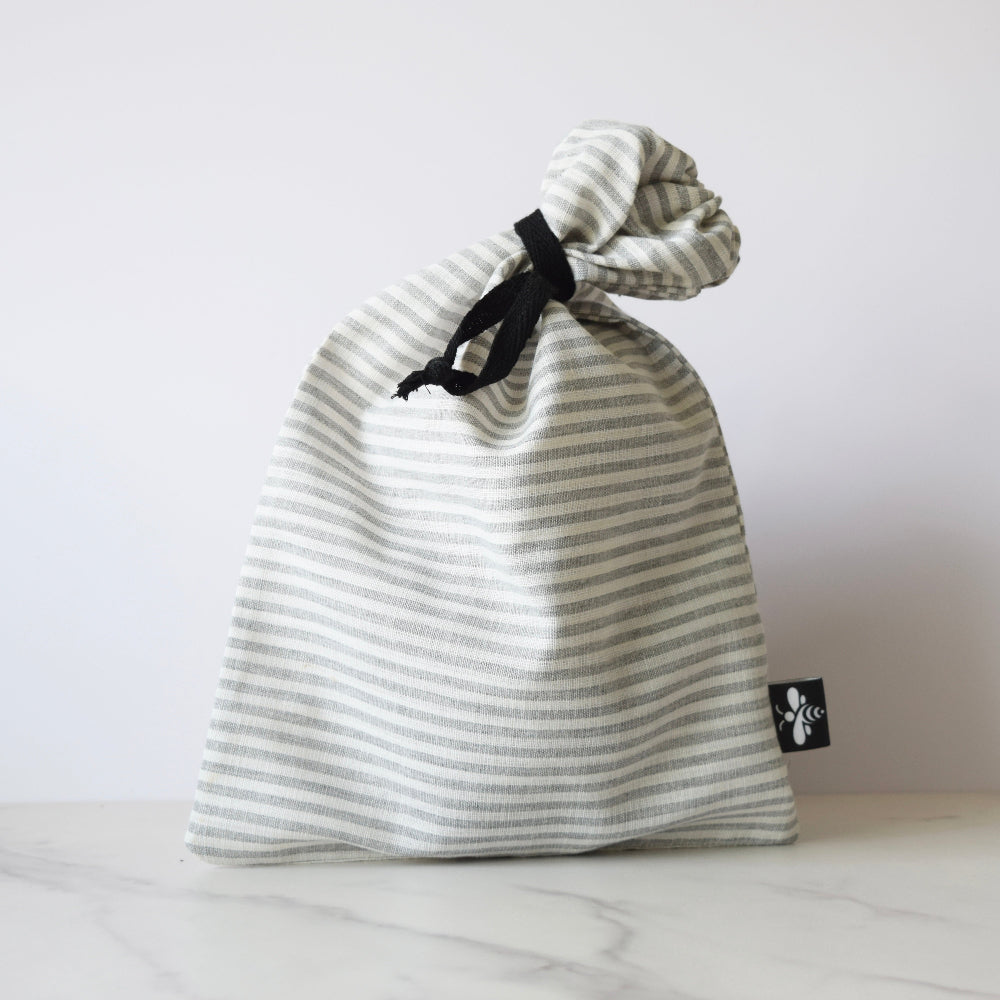 Striped drawstring bag with a brand label on a light background