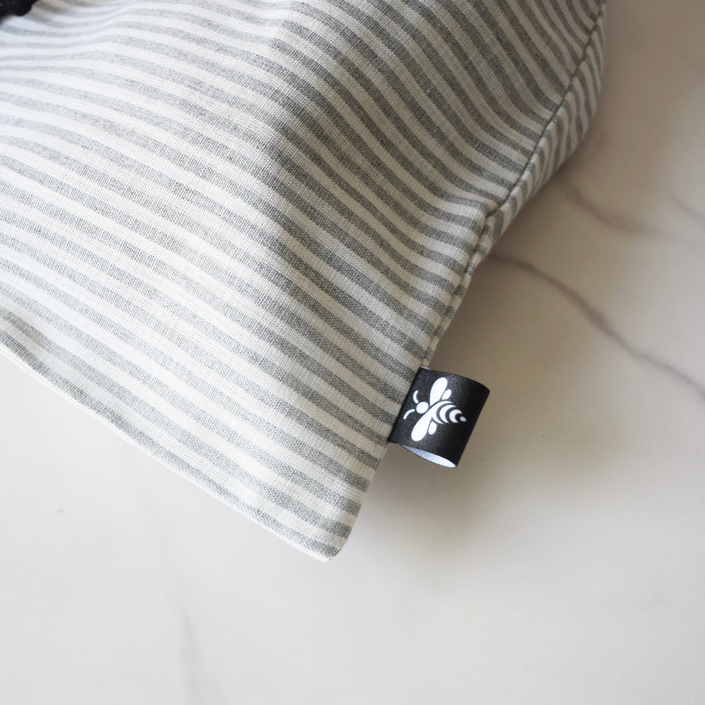 Striped drawstring bag with a brand logo on a white background