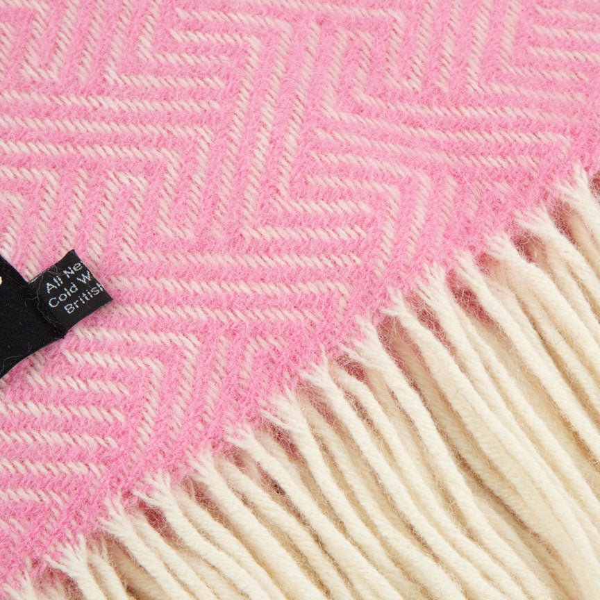 Close-up of a pink and white herringbone patterned fabric with a brand label.
