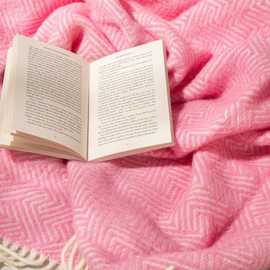 Open book on a pink textured blanket