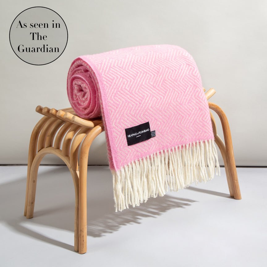 Pink blanket with white fringe on a wooden stool, featuring The Guardian logo.