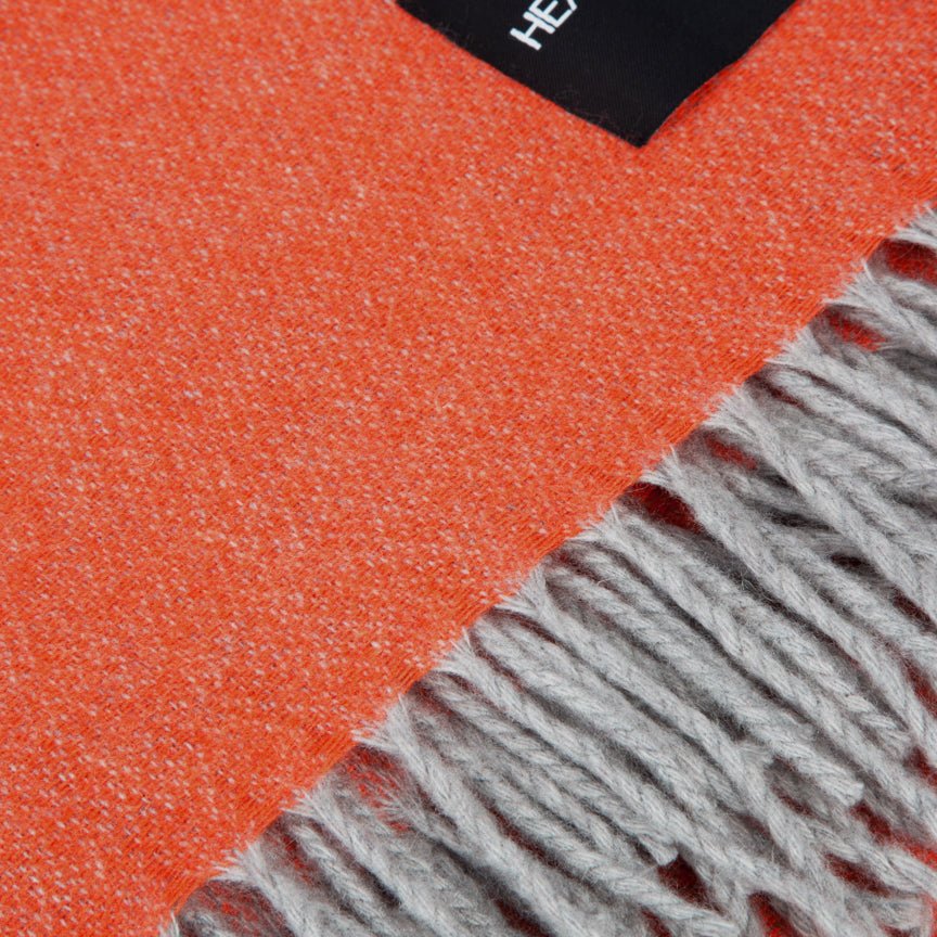 Close-up of an orange and gray blanket with a brand label.