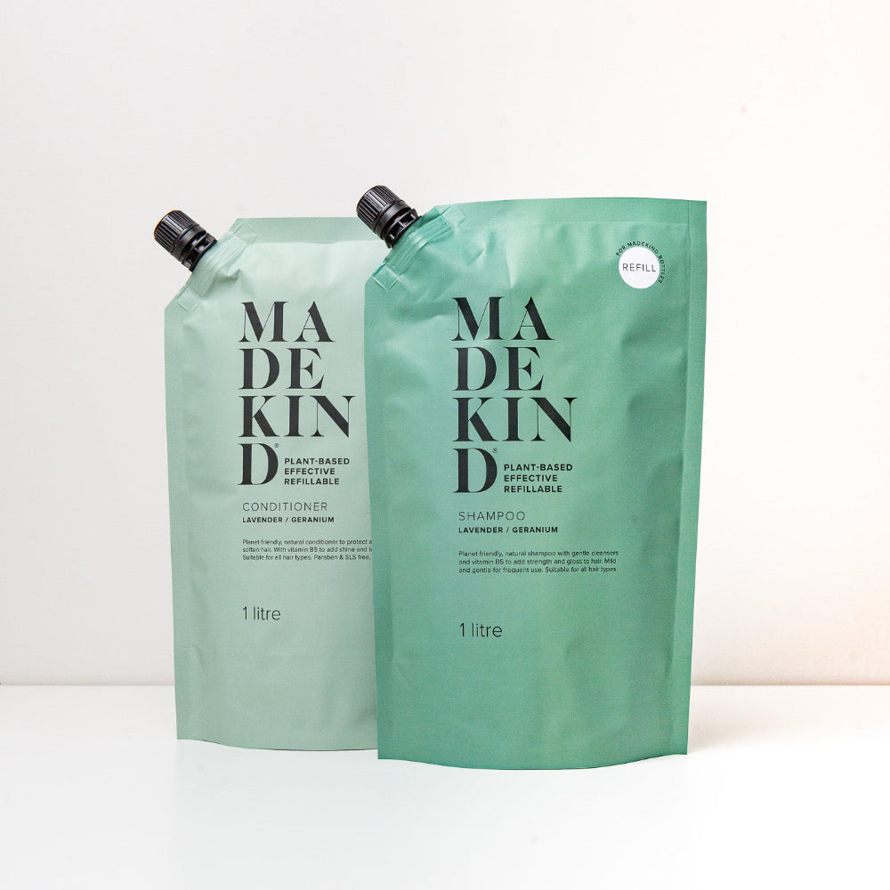Two green refillable bottles Shampoo and Conditioner labelled 'MADE KIND' on a white background