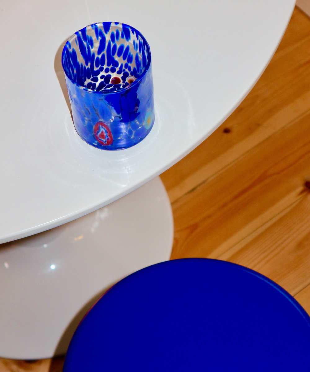 Blue Murano handblown glass tumbler with spotted pattern on a white surface