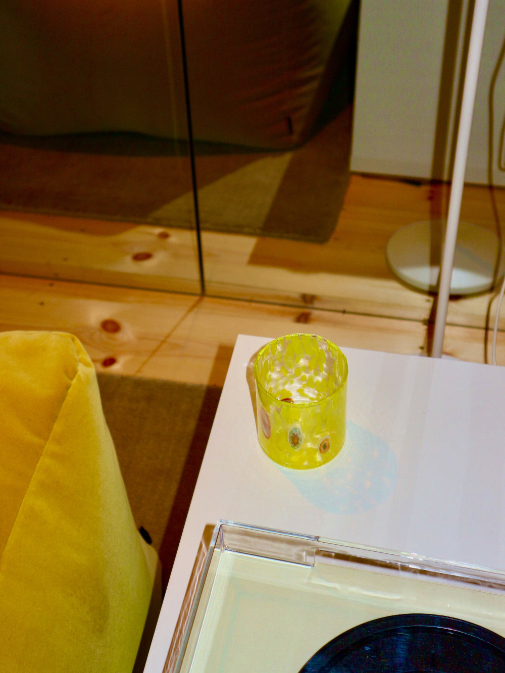 Yellow glass tumbler on a table with a blurred background