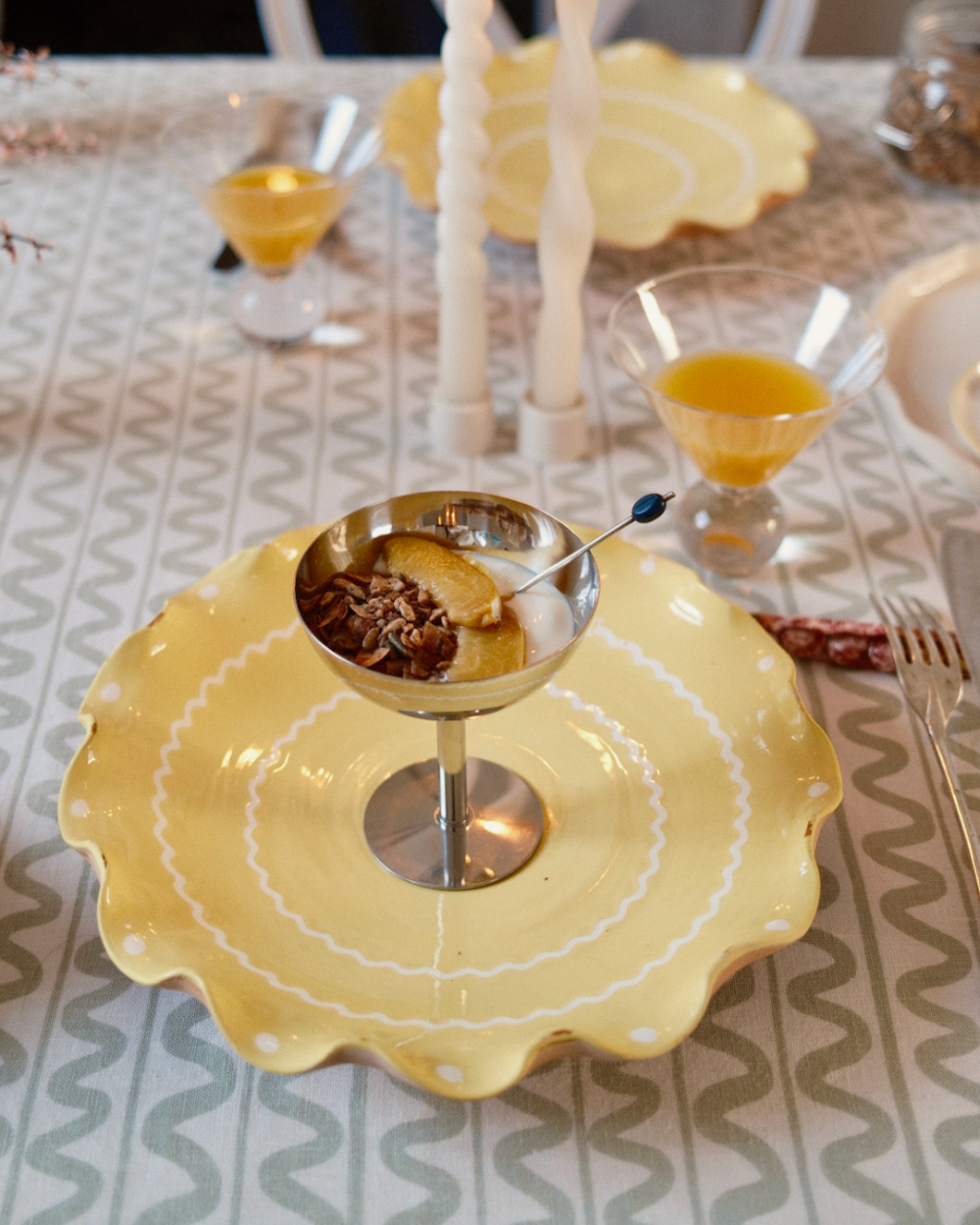 Yellow decorative plate with a small dish on a patterned tablecloth