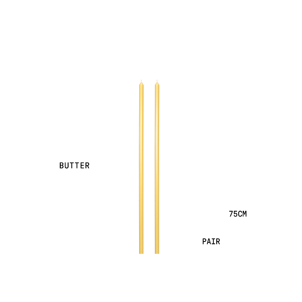 Two tapered candles with text indicating 'BUTTER', '75CM', and 'PAIR' on a white background.