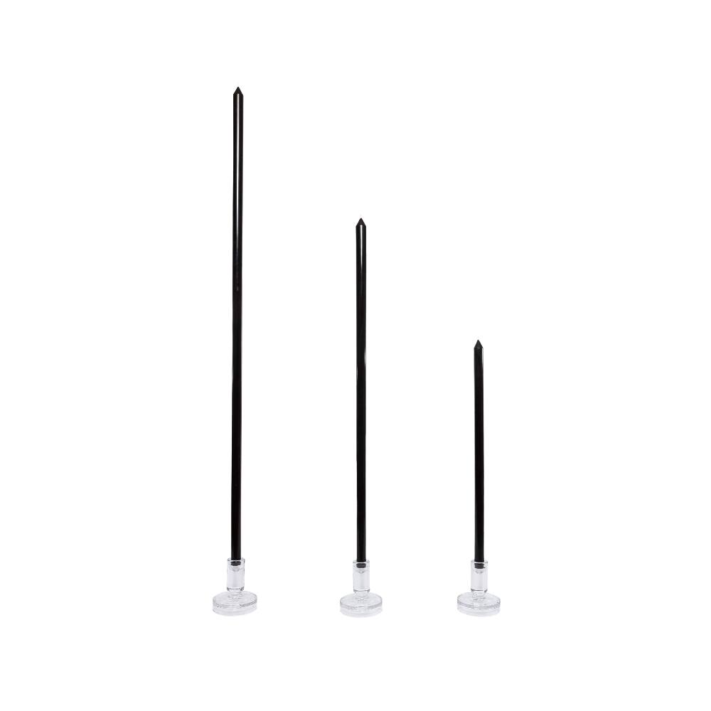 Three black candles with clear bases on a white background