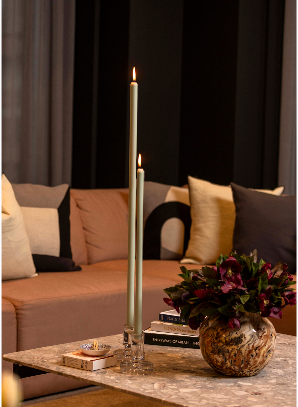 Decorative setup with mint green candles and flowers on a coffee table in a living room.