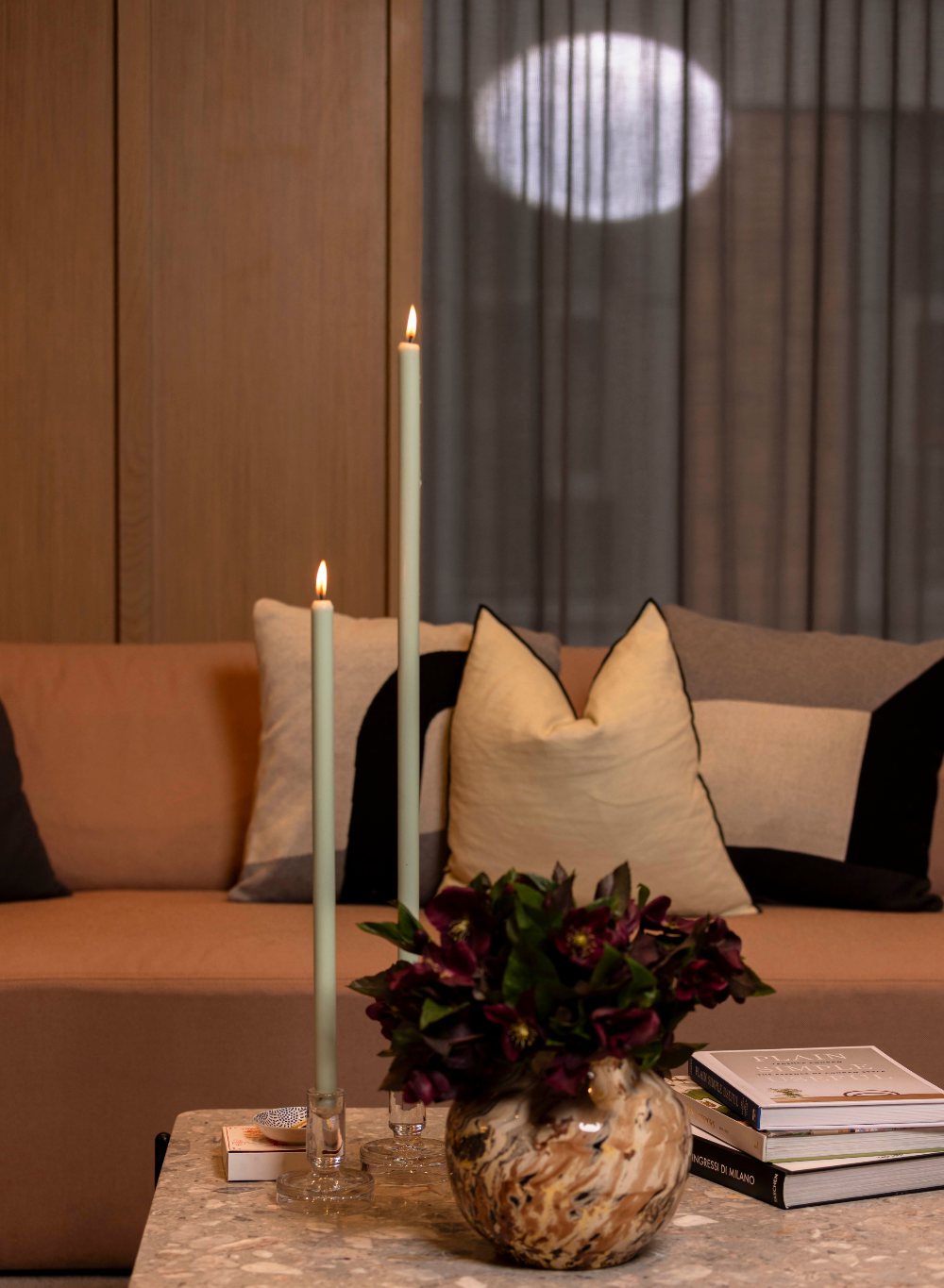 Decorative setup with candles and a vase on a coffee table in a living room.