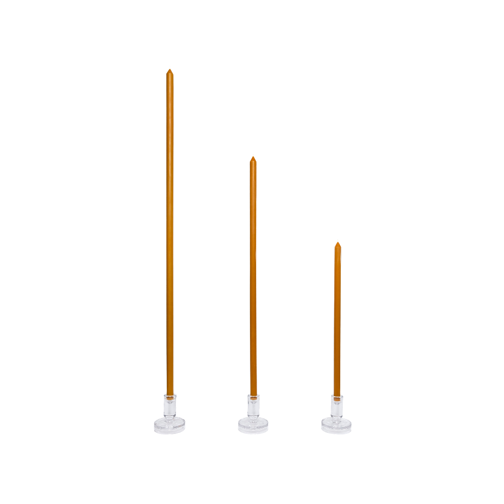 Three tall, thin candles on white stands against a white background
