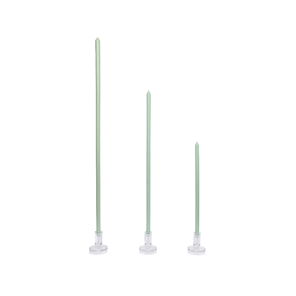 Three green candles with white bases on a white background