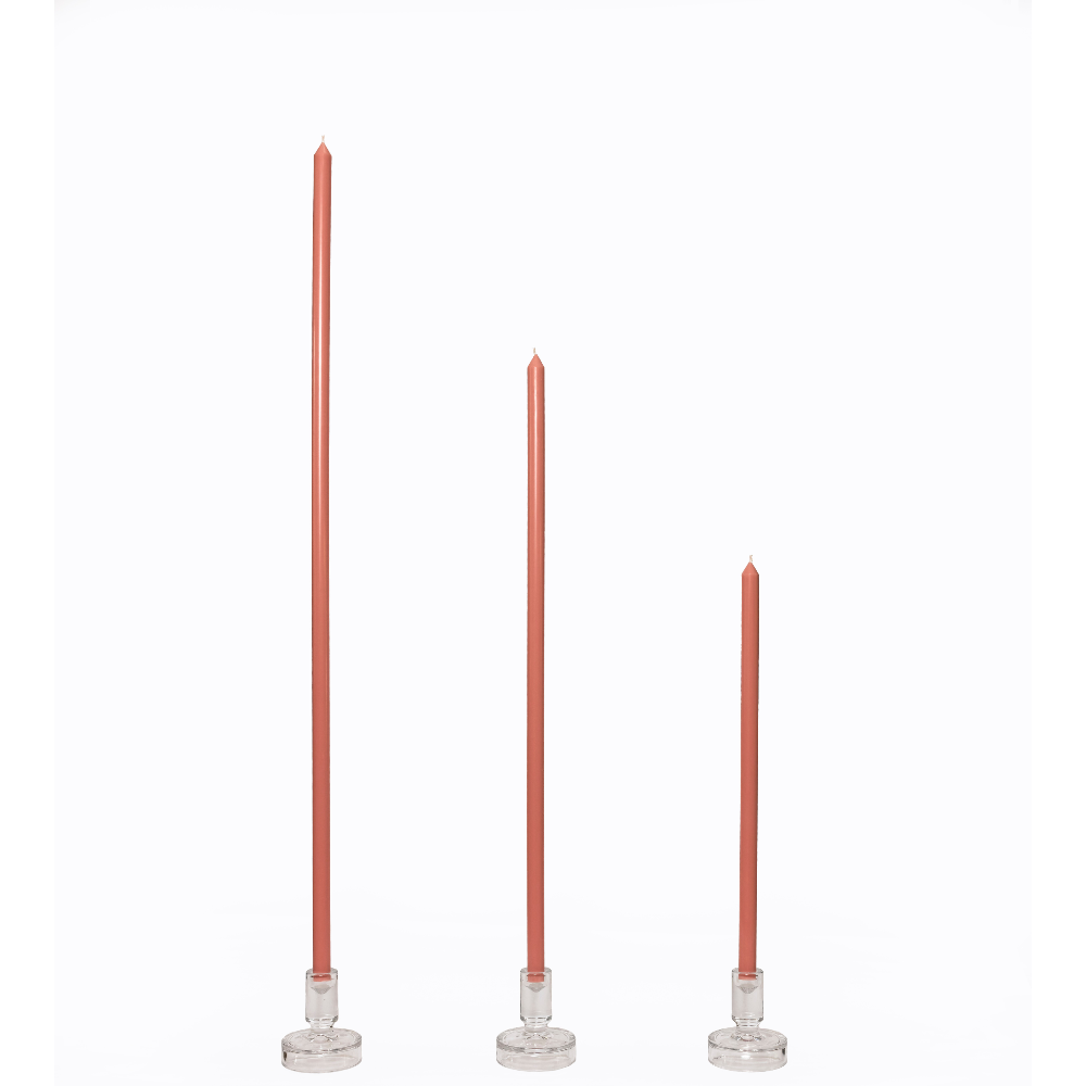 Three tapered candles with clear candle holders on a white background