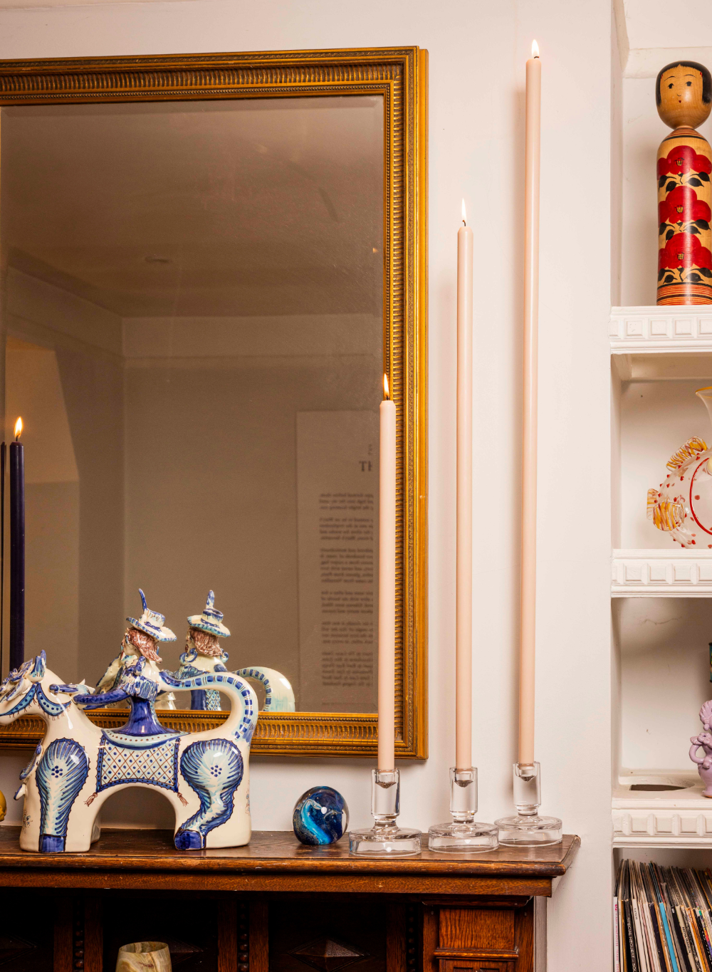 Decorative items on a wooden surface with a mirror and candles in the background