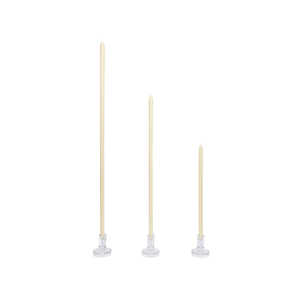 Three tall candles on white stands against a white background