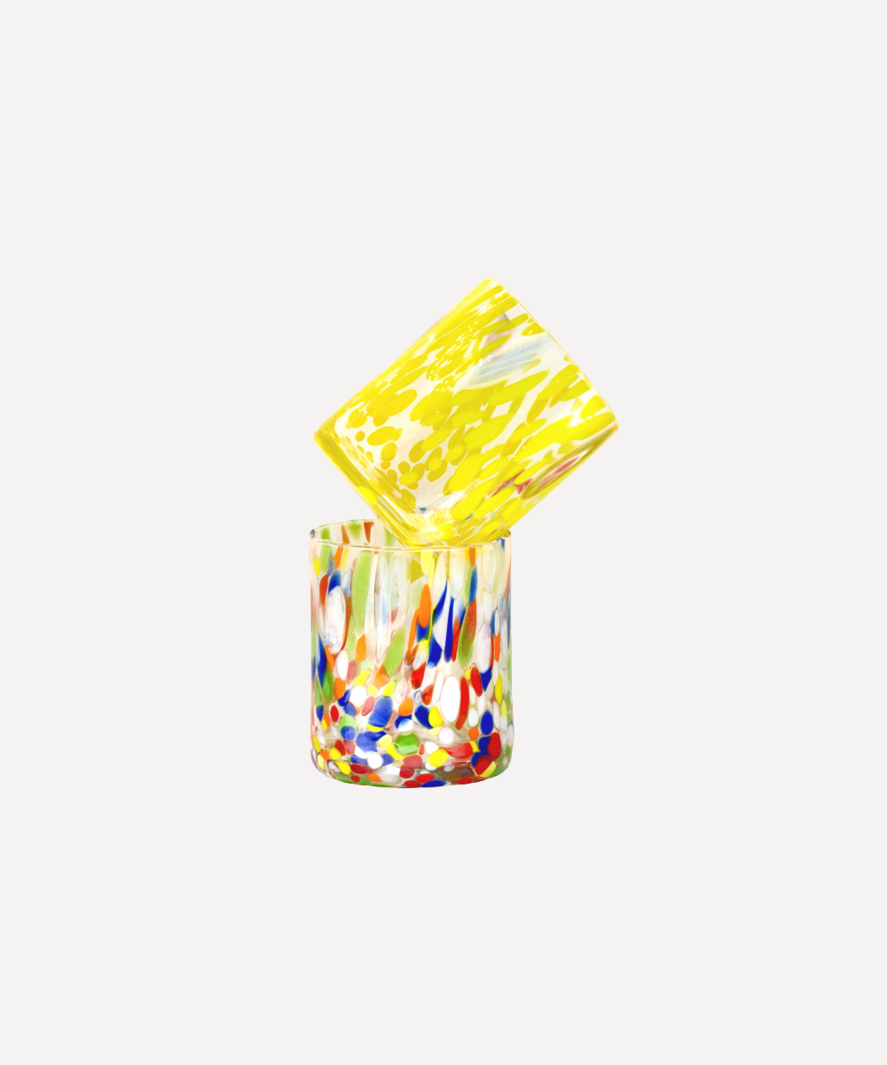 Colourful glass tumbler with a yellow lid on a white background