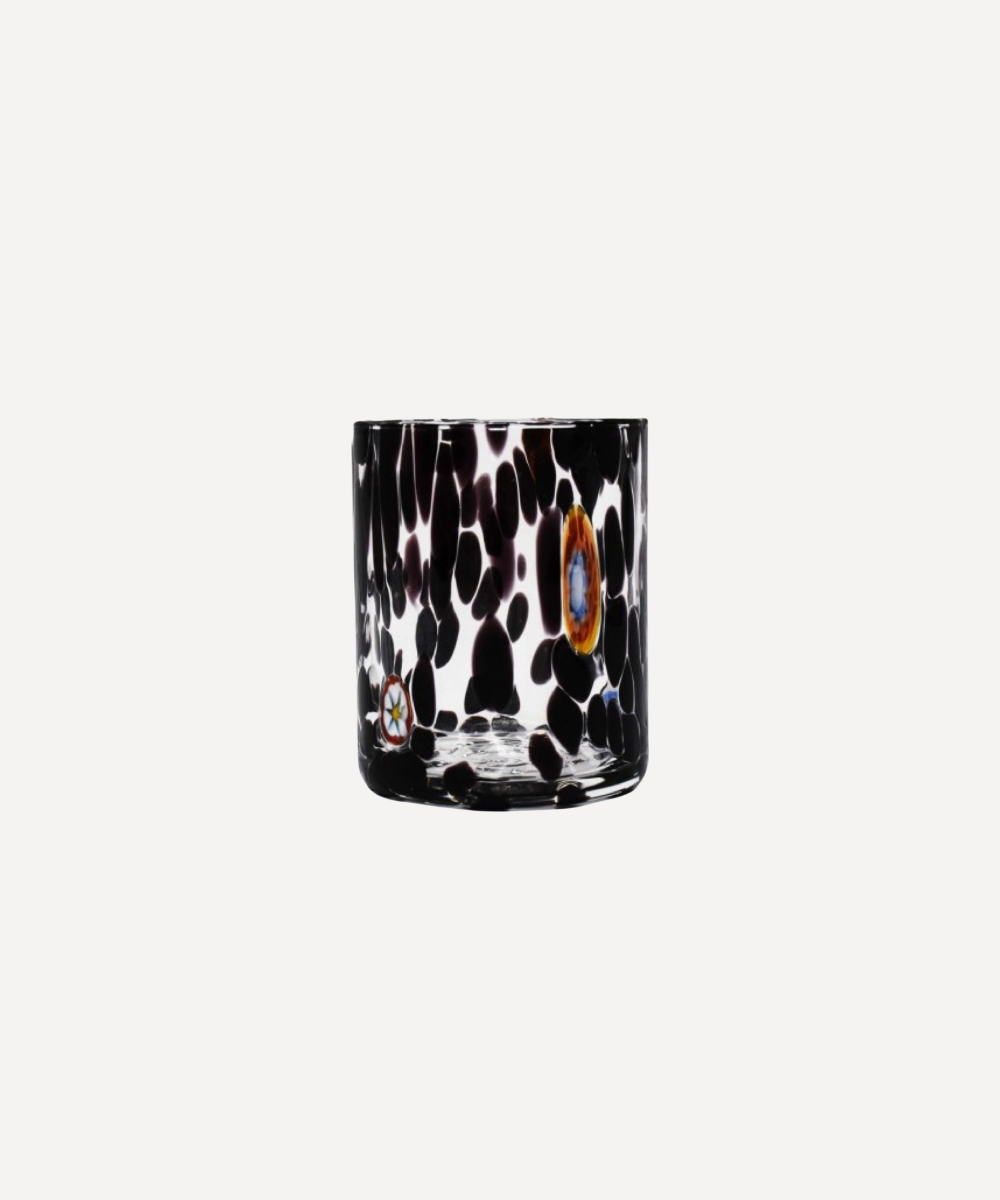 Decorative glass tumbler with black and white abstract pattern on a white background