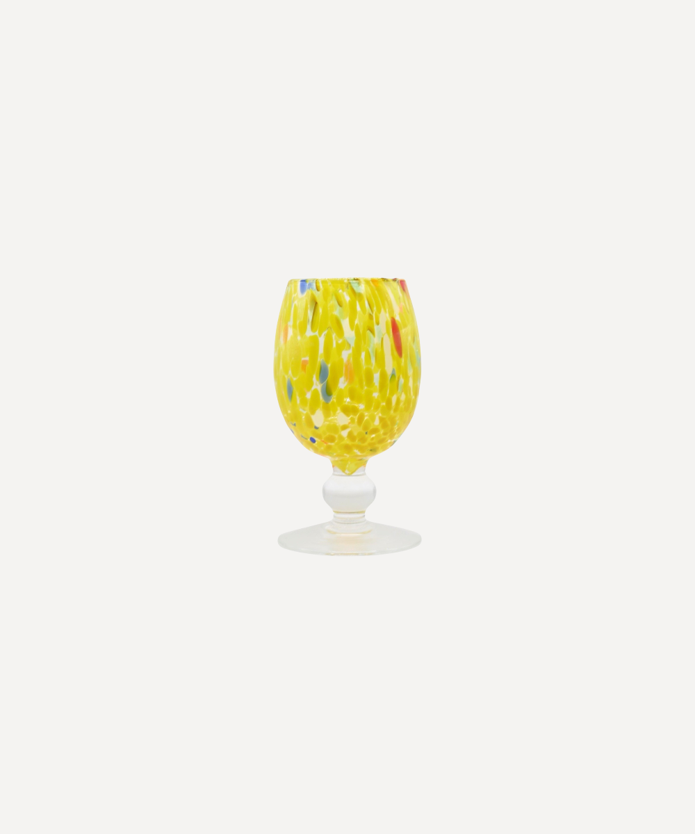 Yellow glass with multicolor pattern on a white background