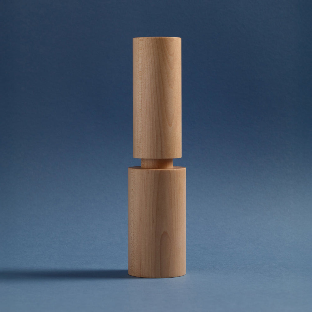 Wooden pepper grinder on a blue background