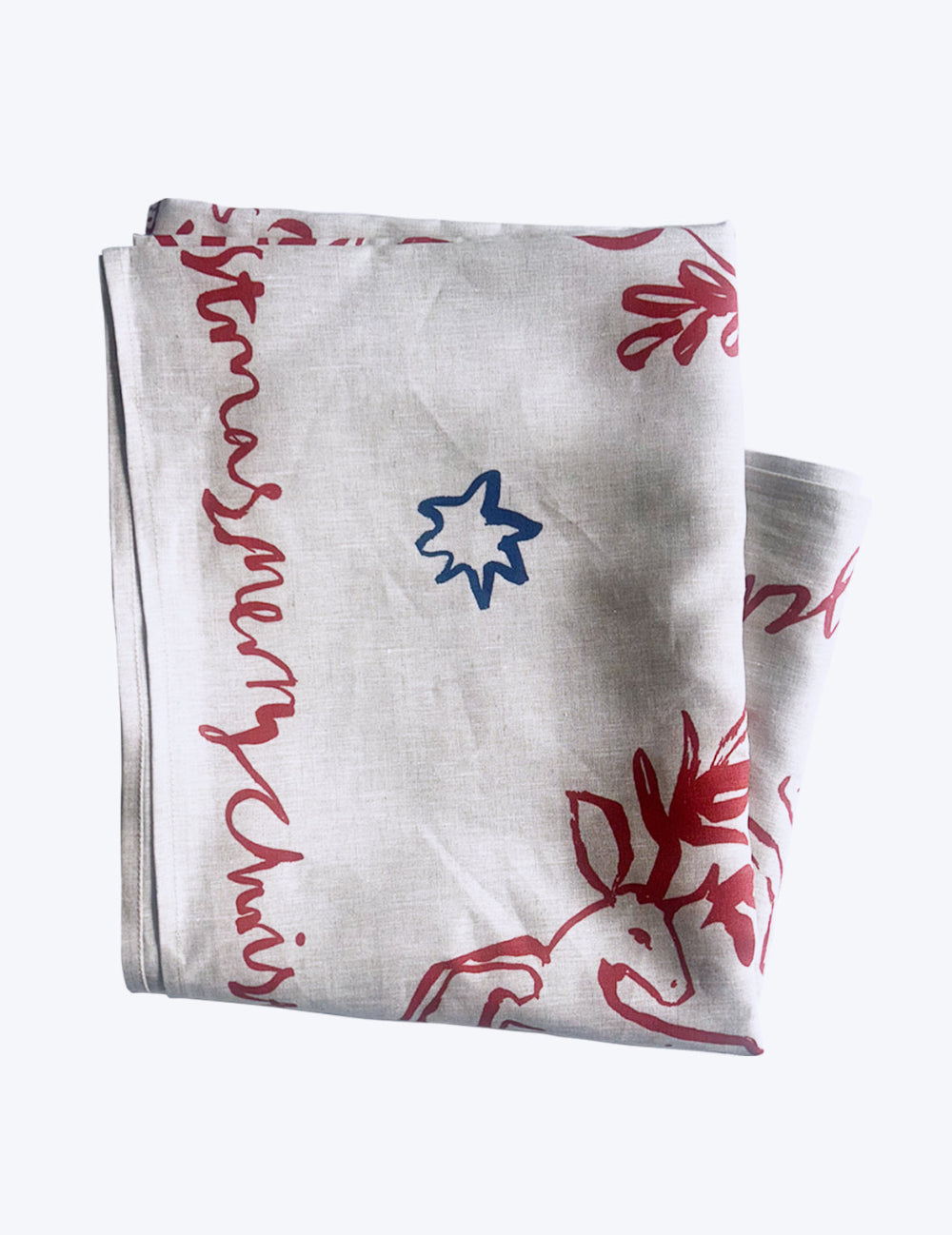 Folded linen tablecloth with red cherubs and reindeer patterns and blue star on a white background