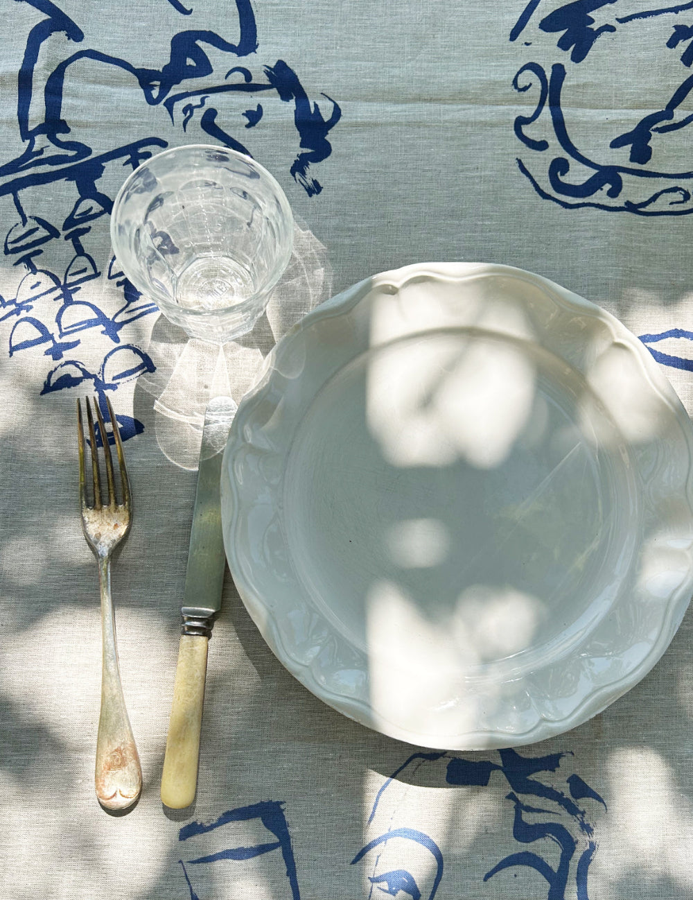 White ceramic plate with a fork on a blue and white patterned linen tablecloth