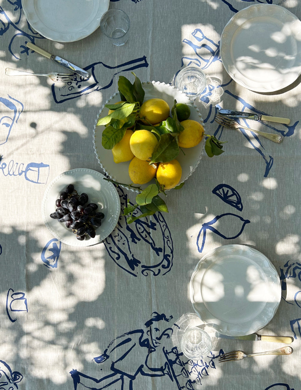 Table setting with lemons and limes on a decorative tablecloth 