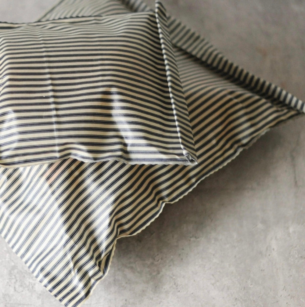 Striped cotton beeswax bags with black and white lines on a grey surface