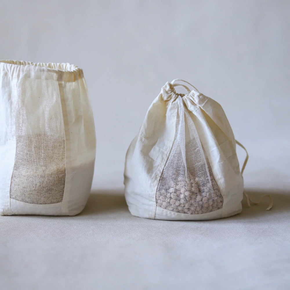Two drawstring bags made of textured fabric on a light background