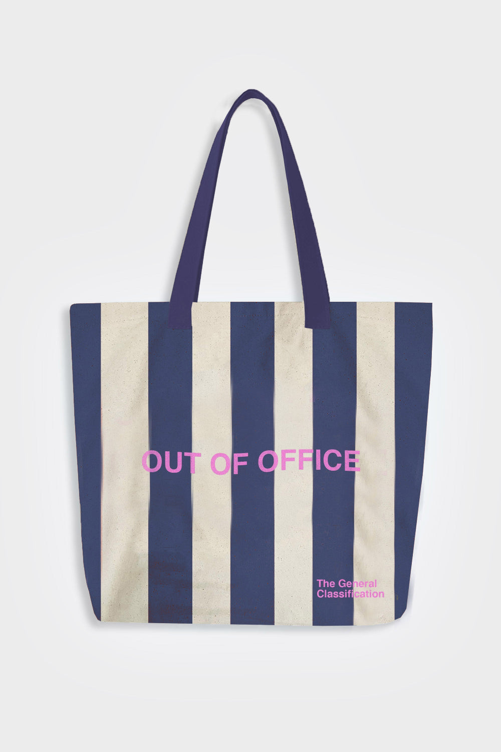A canvas tote bag with vertical navy blue and cream stripes, featuring pink text that reads 'OUT OF OFFICE' and a small logo for 'The General Classification' on the lower right.