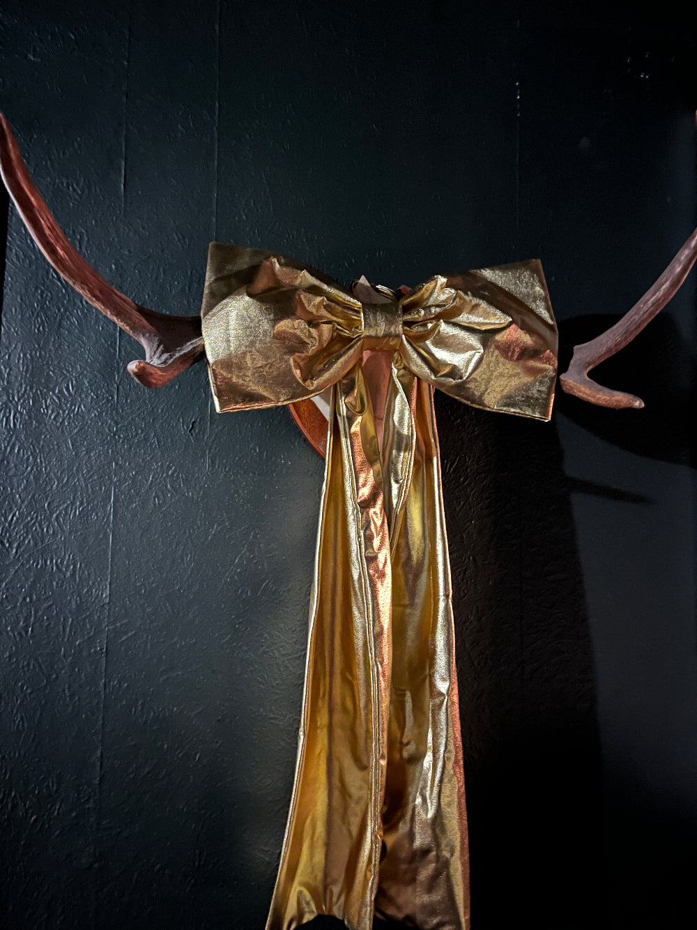 Oversized gold foil bow displayed as a statement Christmas decoration in the home