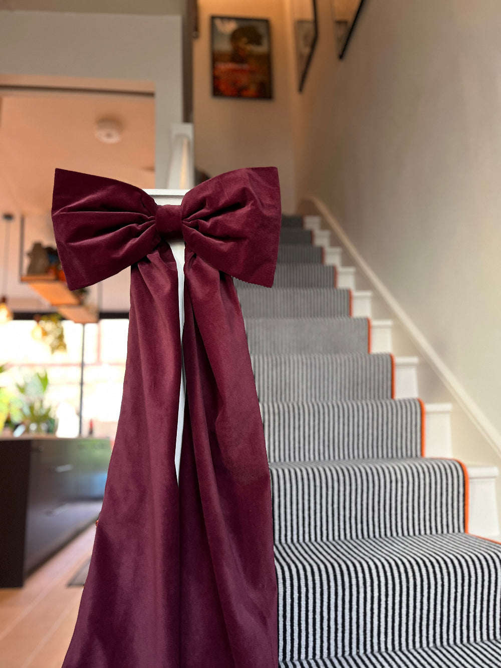 Oversized velvet bow creating a festive Christmas staircase display