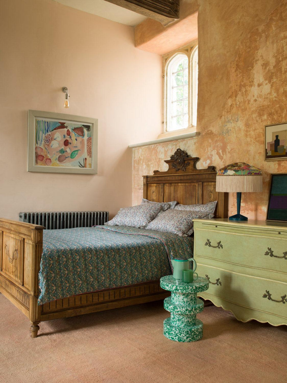 Vintage bedroom with wooden bed, green dresser, and decorative elements.