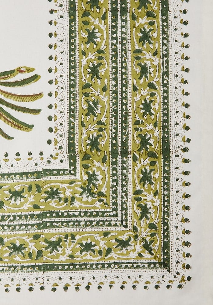 Decorative green and white patterned tablecloth with intricate designs.