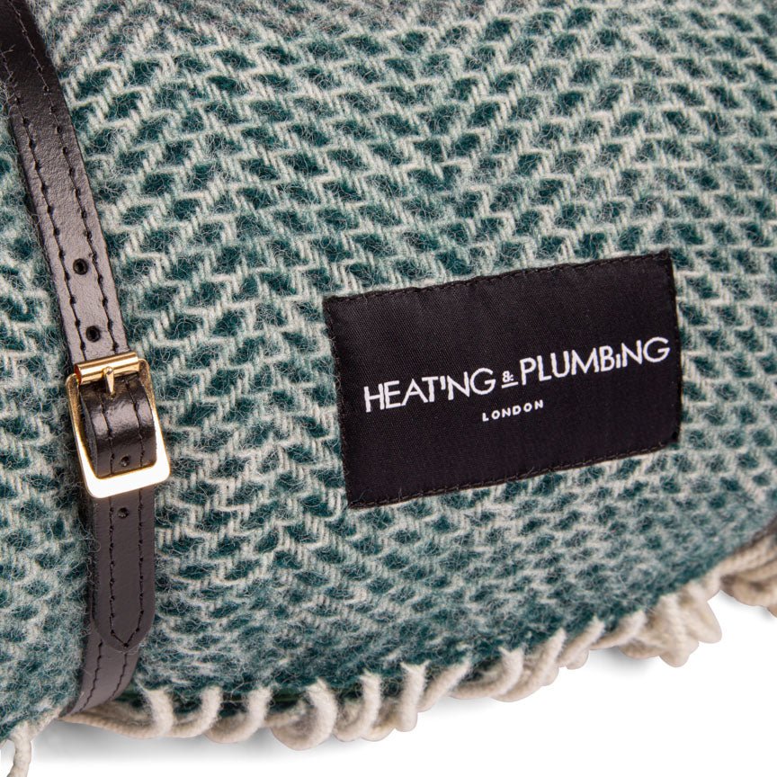 Blanket with 'Heating & Plumbing London' label on a textured fabric background