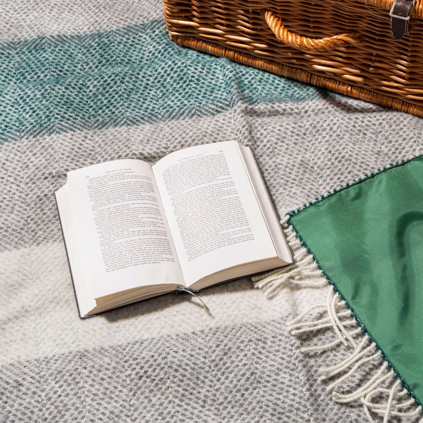 Open book on a textured blanket with a wicker basket in the background