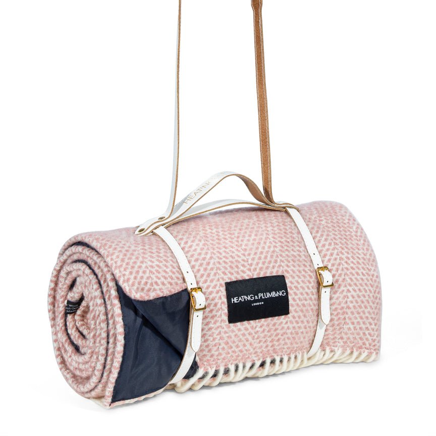 Pink picnic blanket with a black label on a white background
