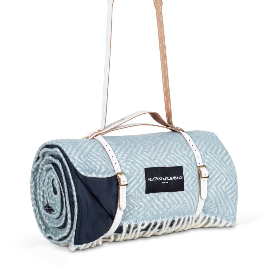Roll-up picnic blanket with carrying strap on a white background